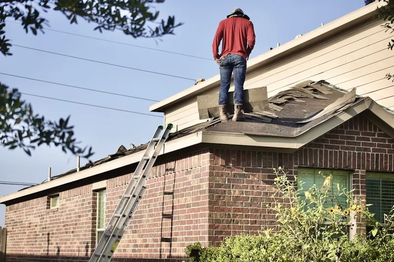 Professional roofer working on a residential roof in Pierceville